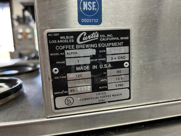 Curtis ALP3GTR12A000 coffee brewer with 3 warmers, 120V. Label shows model, voltage, and NSF certification. Made in USA.