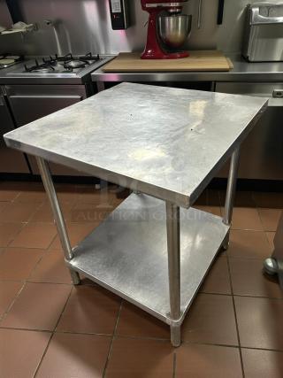 Stainless steel work table by Eagle Group, featuring a two-tier design in great condition, suitable for commercial kitchens.