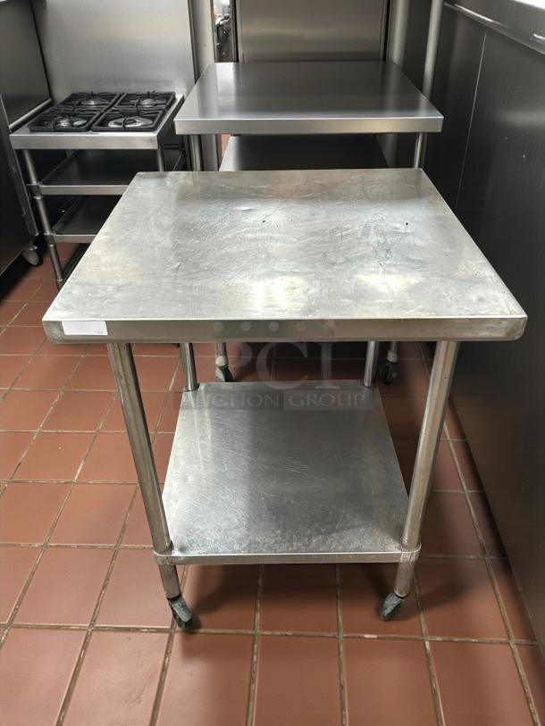 Eagle Group stainless steel work table, excellent condition, features two shelves and caster wheels for mobility.