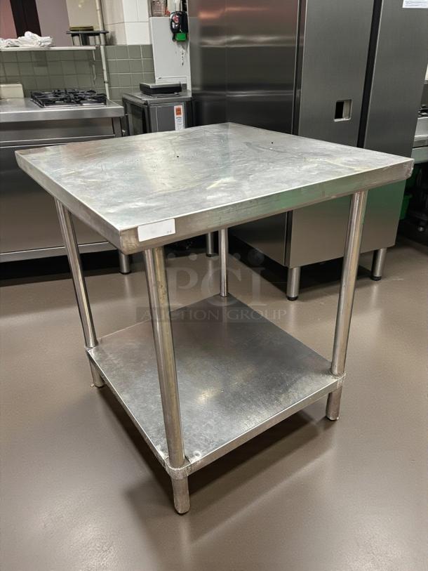 Stainless steel work table by Eagle Group in great condition, featuring a lower shelf and sturdy legs. Ideal for kitchen use.