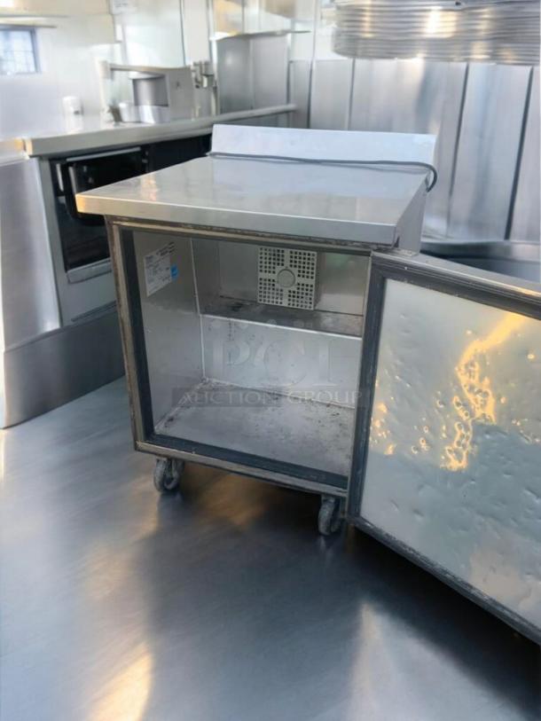 True TWT-27F one-door worktop freezer, prime condition, stainless steel, 115V, fully tested, on casters, interior shelving.