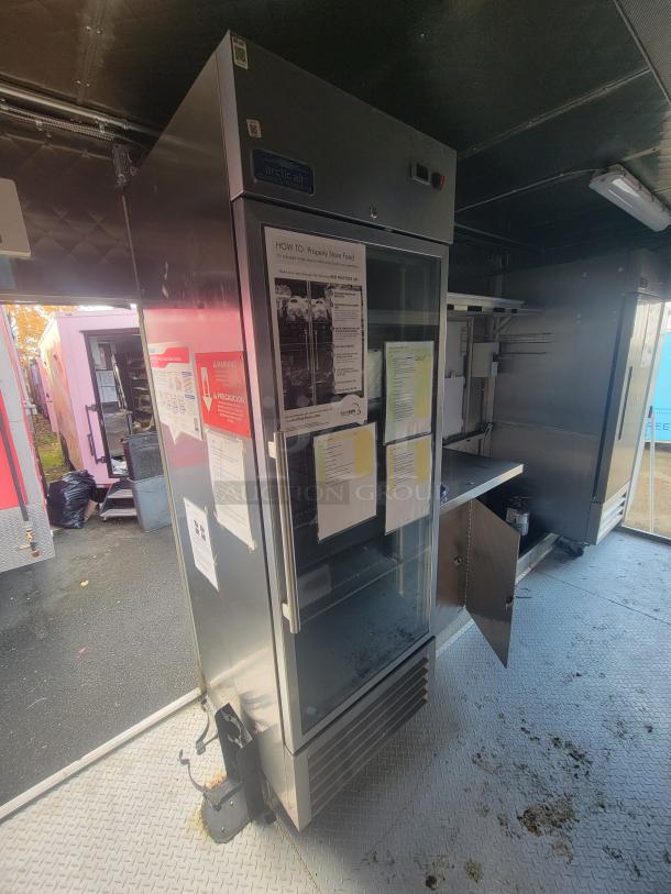 2021 commercial food trailer interior with Arctic Air freezer, stainless steel finishes, and service window.