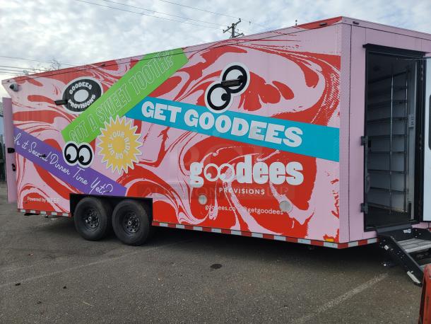 Pink and red 2021 SDG "Goodees" retail/food trailer with vibrant wrap, triple pink doors, displayed on an asphalt surface.