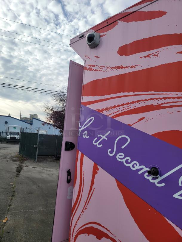 Vibrant pink and red 2021 SDG trailer with "Goodees" wrap, exterior security camera, and purple "Powered by REEF" marking.