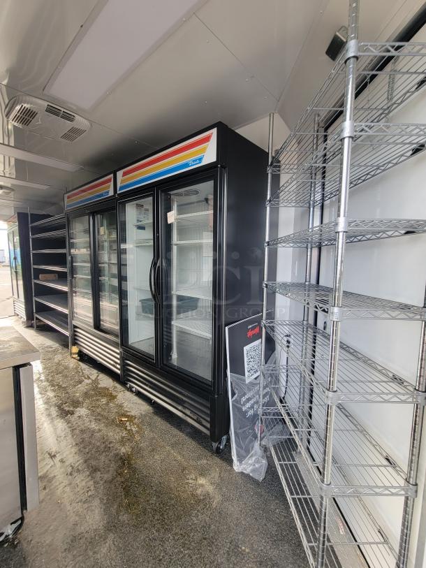 Interior of 2021 SDG trailer with True Refrigeration units, chrome shelving, stainless steel counter, and hand sanitizer dispenser.