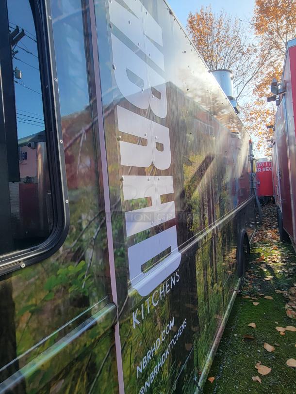 2004 Freightliner MT45 mobile kitchen van, side view with branded wrap, parked outdoors. Perfect for catering or ghost kitchens.