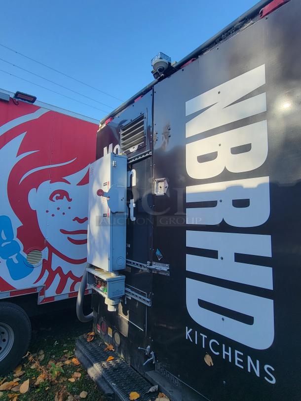2004 Freightliner MT45 mobile kitchen, black exterior with "NBRHD Kitchens" text. External connections visible.