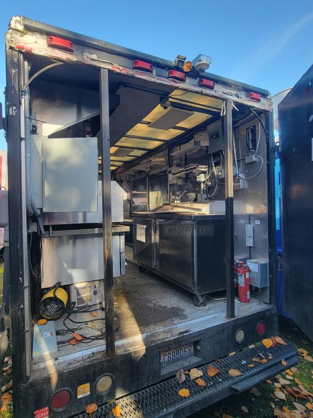 Freightliner MT45 mobile kitchen van, stainless steel interior, includes griddle, fryer, fridge, and fire suppression system.