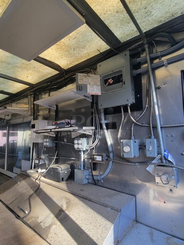 2004 Freightliner MT45 Mobile Kitchen interior showing electrical panels, outlets, and stainless steel walls.