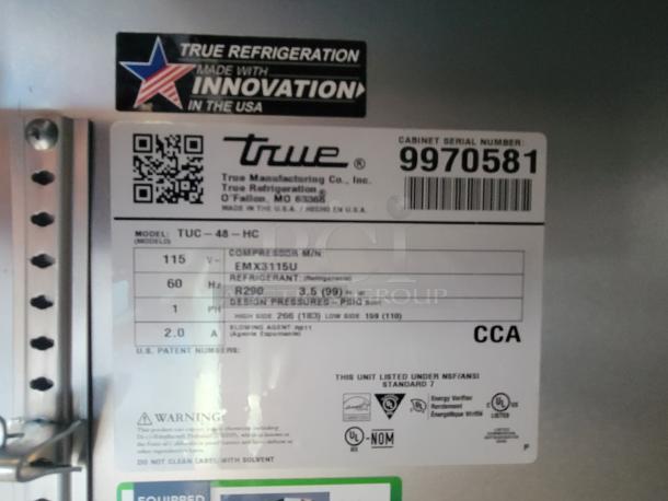 Label on refrigeration unit showing True brand, model TUC-48-HC, serial 9970581, and specifications including voltage and refrigerant type.
