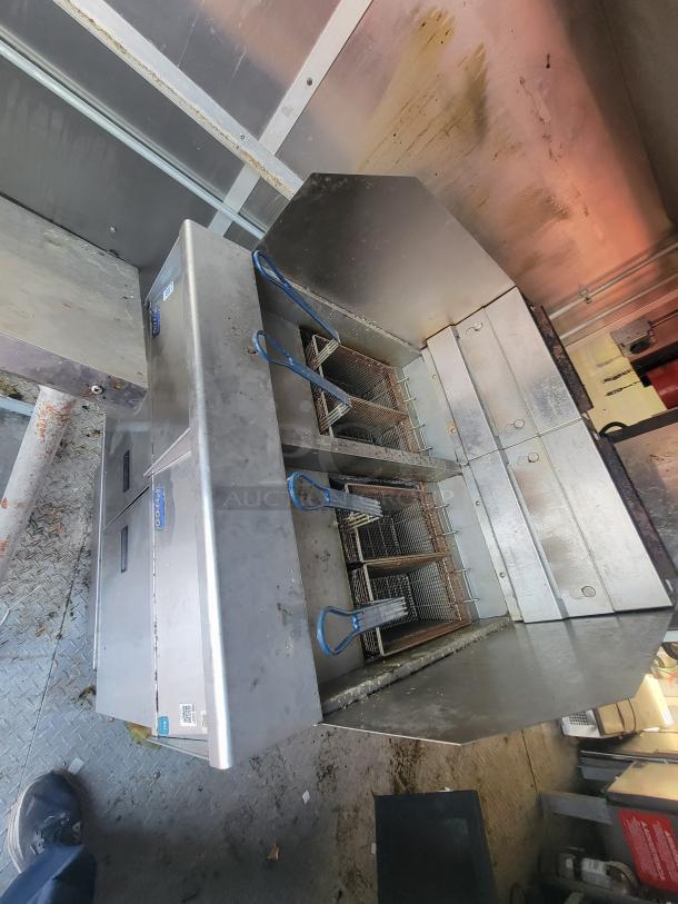 Stainless steel deep fryer in a 2020 Diamond Cargo mobile ghost kitchen trailer; features multiple frying baskets and commercial-grade construction.