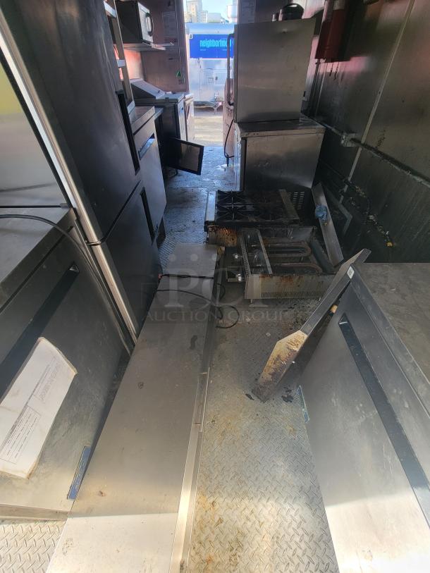 Fully-equipped 2020 24' Diamond Cargo mobile ghost kitchen trailer. Features stainless steel appliances, commercial cooking line, refrigeration units, sinks, fire suppression, and electrical panel for turnkey operation.