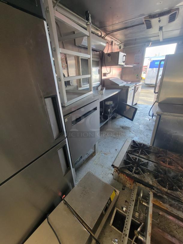 2020 Diamond 24' mobile ghost kitchen trailer interior with stainless steel commercial equipment, including a gas range, fryers, and fridges.