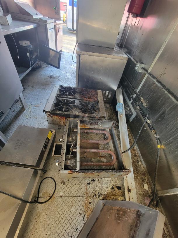 24' Diamond Cargo mobile kitchen trailer interior with commercial-grade cooking equipment, stainless steel appliances, and visible wear.