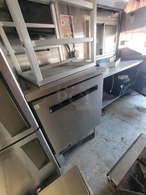 2020 Diamond Cargo 24' mobile kitchen trailer interior with stainless steel equipment, including refrigeration unit and commercial-grade cooking line.