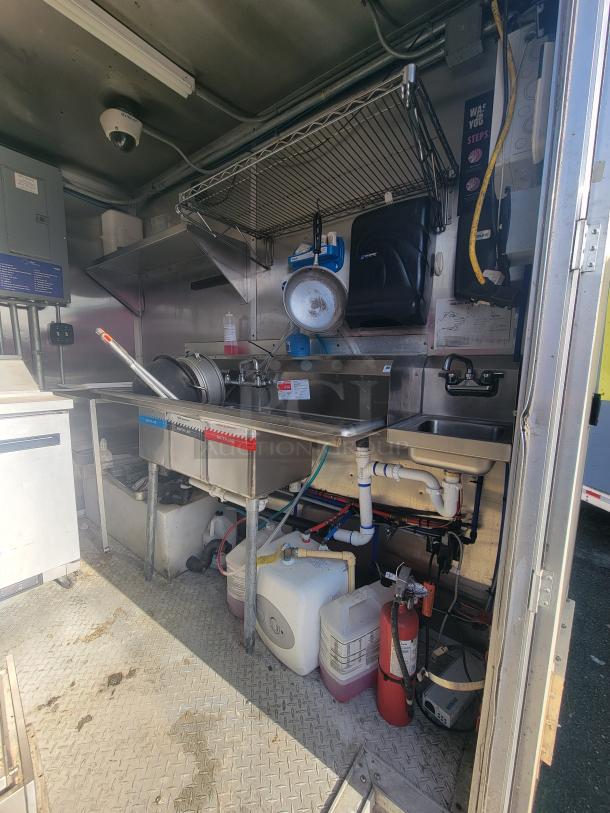 2020 24' Mobile Ghost Kitchen Trailer interior with stainless steel sink, plumbing, and equipment. Includes fire extinguisher.