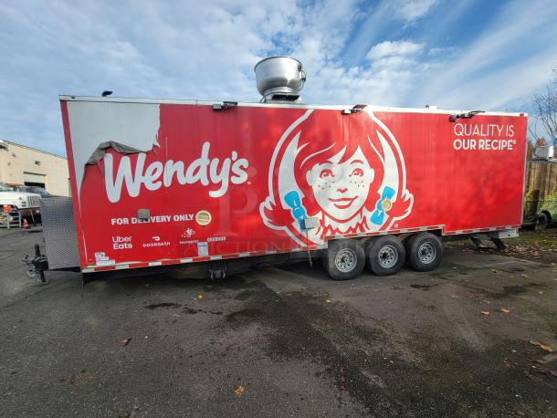 Custom 2022 28' Titanium Cargo Food Trailer with commercial kitchen, vibrant red Wendy's branding, and triple axles.