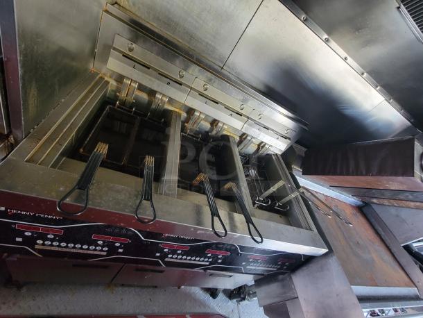 Henny Penny Gas Pressure Fryer inside 2022 Titanium Cargo 28' food trailer, featuring multiple compartments and control panels for high-volume cooking.