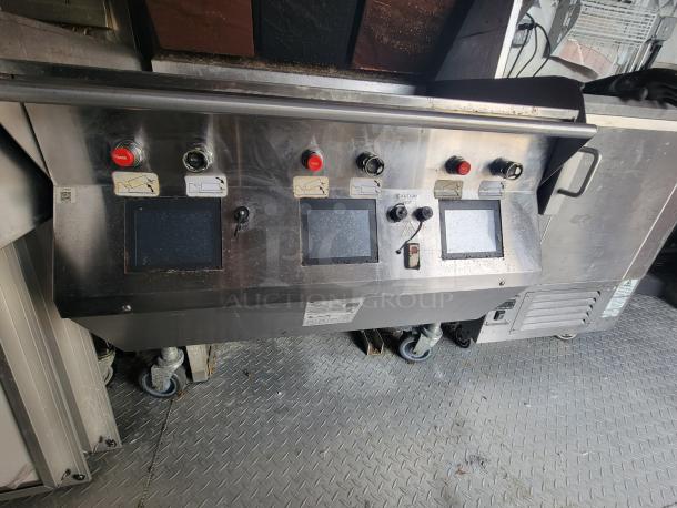 Stainless steel control panel inside 2022 Titanium Cargo 28' Food Trailer, featuring touchscreen displays and emergency buttons.