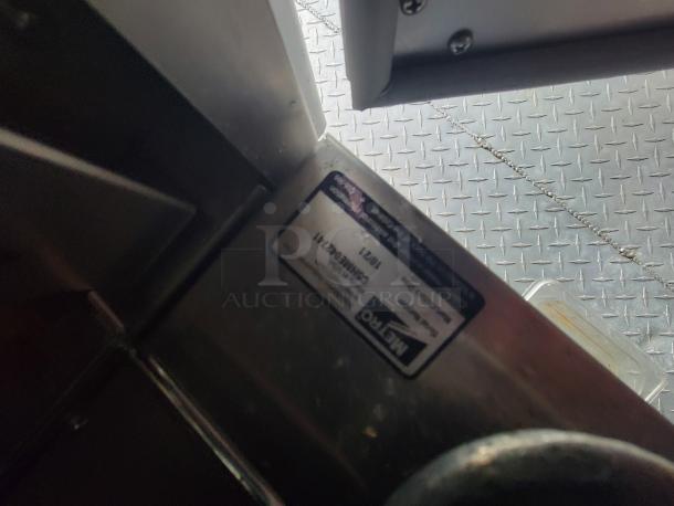 Metal label on a 2022 Titanium Cargo Food Trailer indicating model 28. It's mounted on diamond-plate flooring.