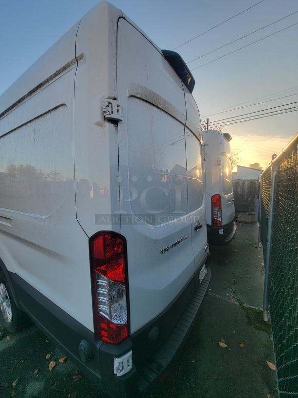 2021 Ford Transit 350 Cargo Van, High Roof, low mileage, shown in parking lot. Marked "Transit" on rear. Clean condition.