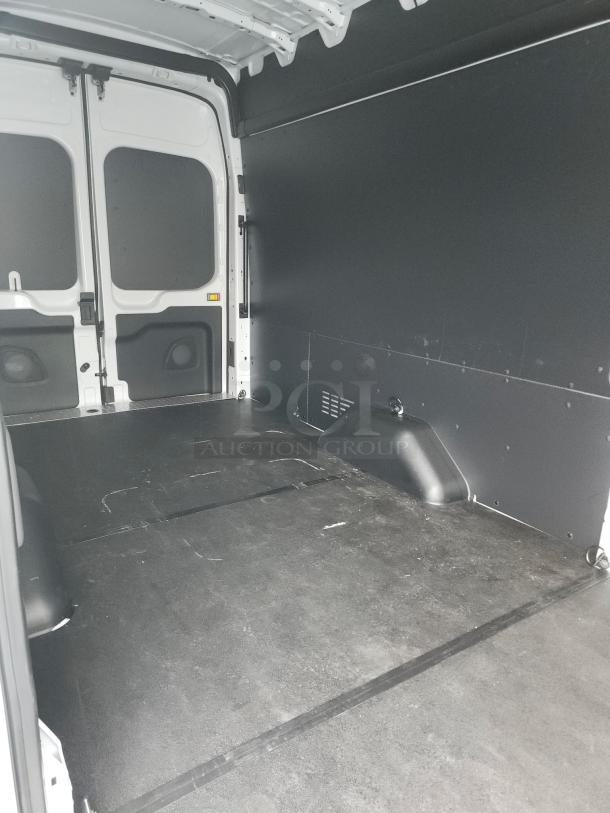 2021 Ford Transit 350 Cargo Van interior, high roof, clean cargo space with floor and wall liners, white door panels visible.