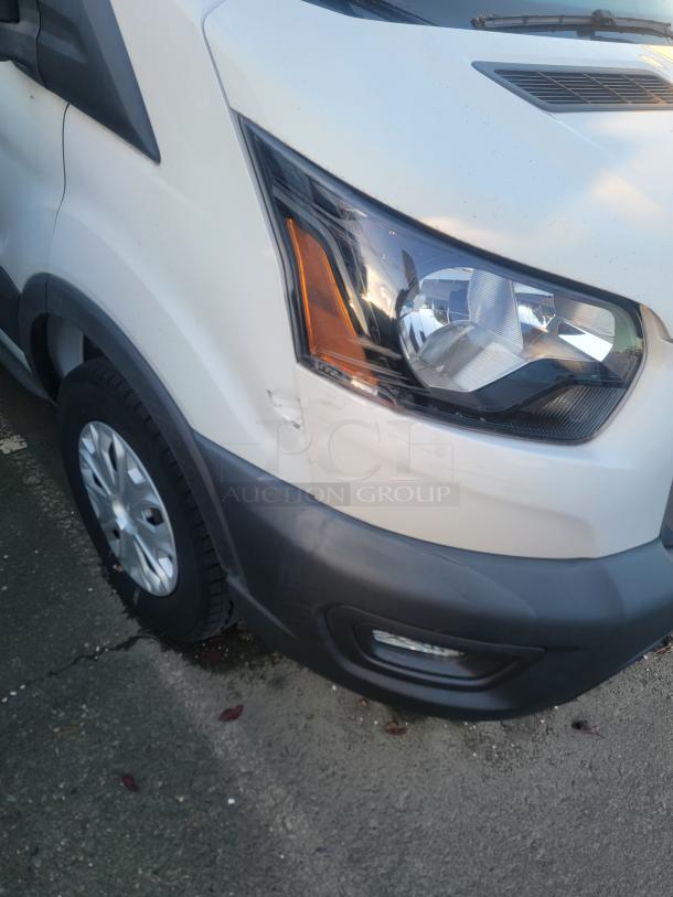 2021 Ford Transit 350 Cargo Van, low mileage, high roof. Close-up of front with minor wear. Ideal for commercial use.