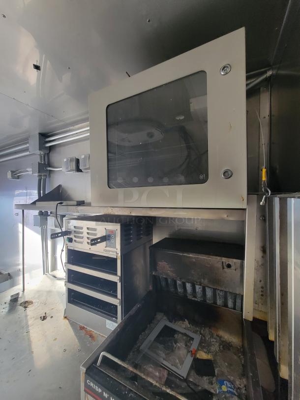 2021 Texino 28-ft food trailer interior with commercial-grade appliances, stainless steel surfaces, and exhaust hood system.