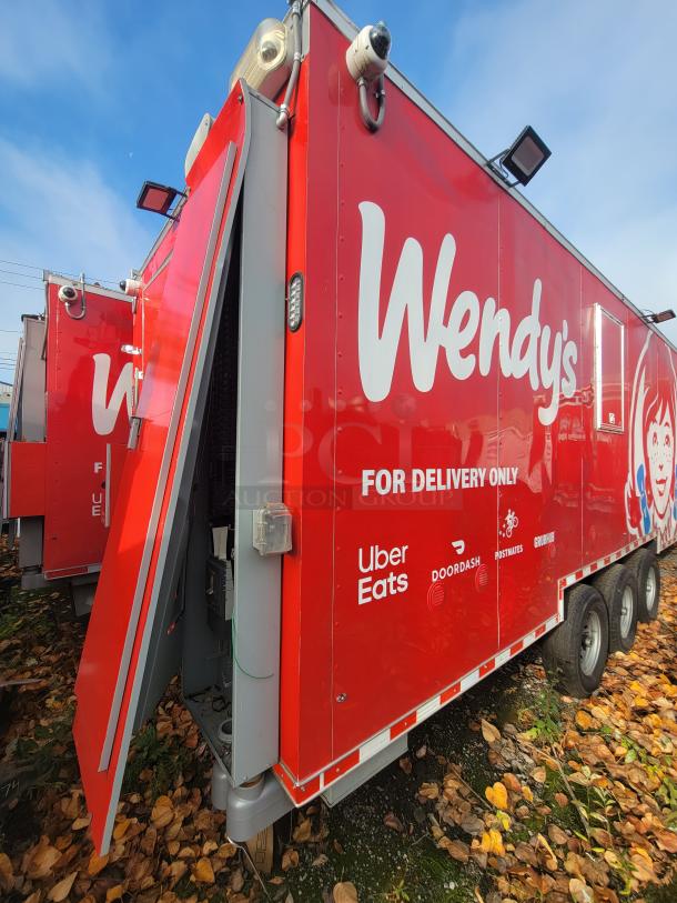 2022 Rock Solid 28' food trailer, red, brand new condition, equipped for high-volume operations. Features premium commercial-grade equipment. Logos for delivery services visible.