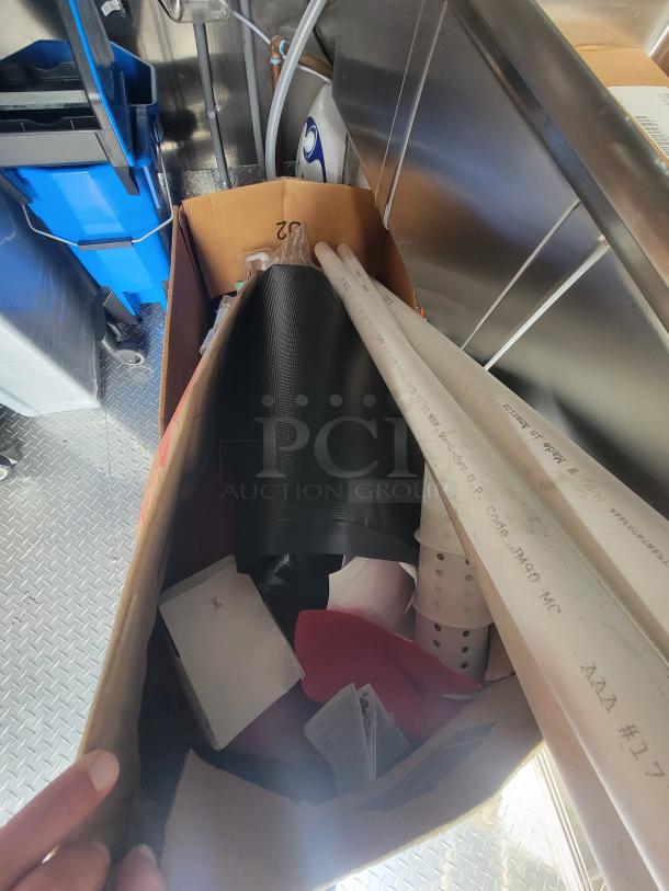 Interior view of a 2022 Rock Solid 28' food trailer, showing brand new, unused equipment and packaging materials.