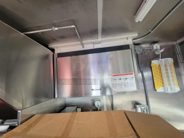 2022 Rock Solid 28' food trailer interior, stainless steel surfaces, pristine condition, commercial-grade equipment, never used.
