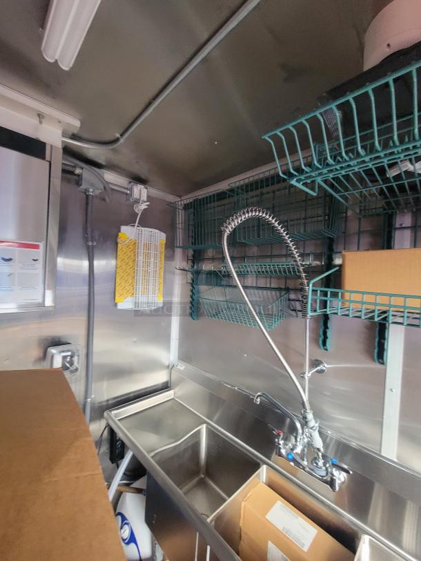 2022 Rock Solid 28' food trailer interior, pristine condition, stainless steel sink, premium unused kitchen equipment.