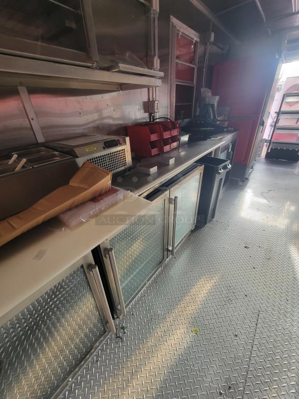 2022 Rock Solid 28' food trailer interior with unused high-end commercial kitchen equipment and stainless steel counters.