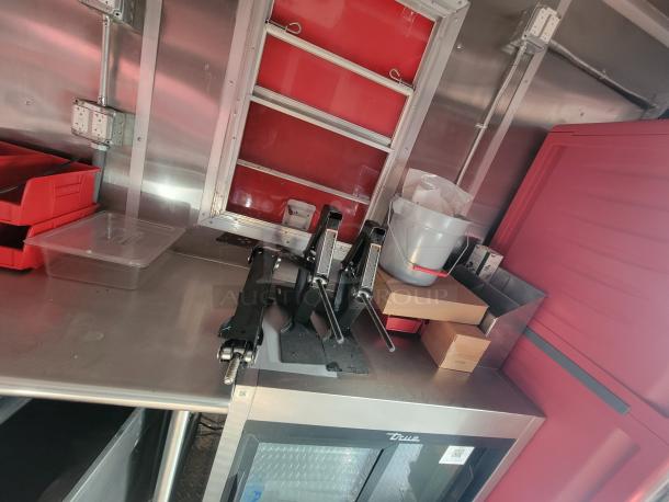 2022 Rock Solid 28' food trailer, interior view. Features stainless steel surfaces, new commercial equipment, pristine condition.