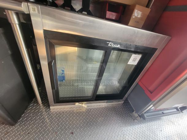 2022 Rock Solid 28' food trailer interior, featuring a new True commercial refrigerator with glass doors, immaculate condition.