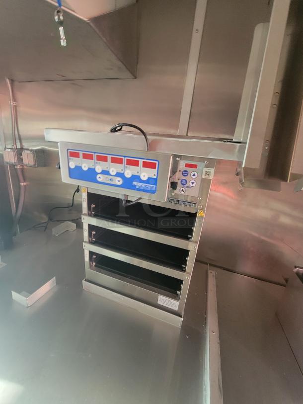 2022 Rock Solid 28' food trailer interior with unused high-end commercial kitchen equipment, pristine condition.