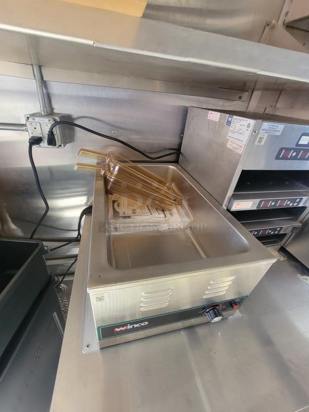 2021 Titanium 28' food trailer interior, featuring pristine, unused Winco appliance with protective material; factory labels visible.