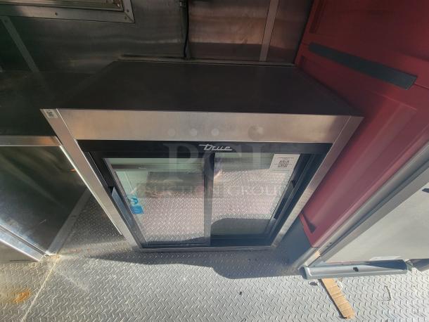 2021 Titanium 28' food trailer interior with unused professional-grade equipment, featuring protective material and pristine condition.