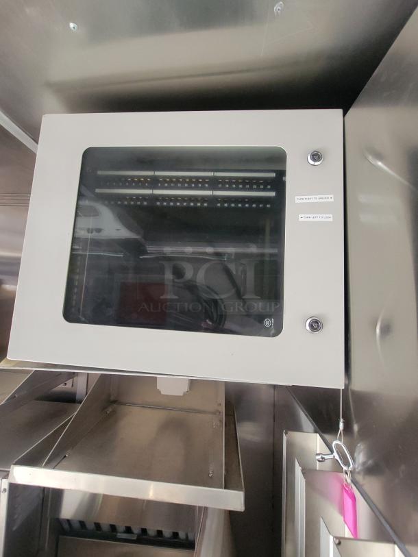 2021 Titanium 28' food trailer interior with unused, professional-grade kitchen equipment, factory protective material visible.