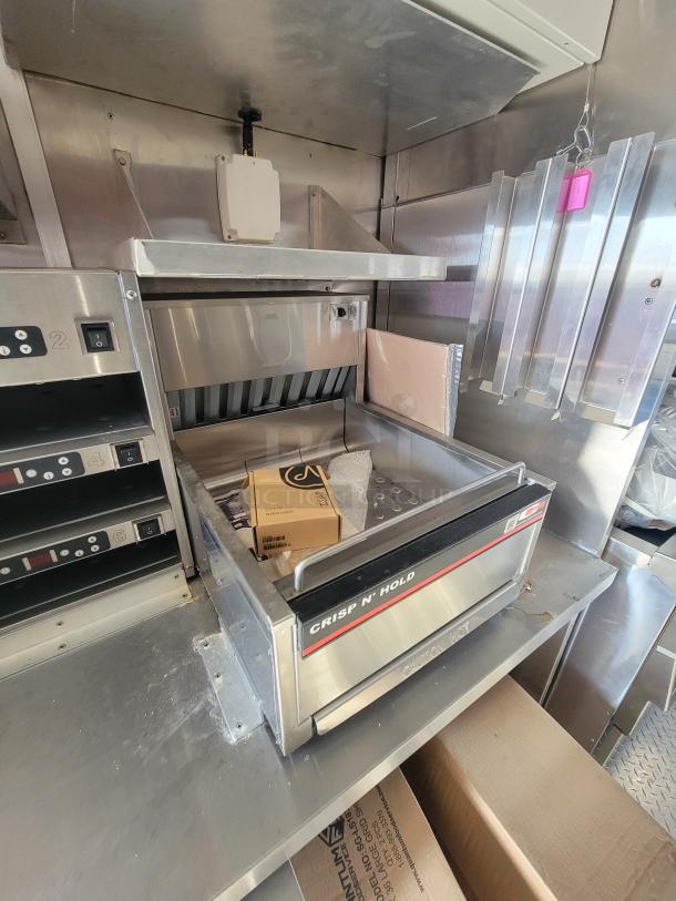 2021 Titanium 28' food trailer, as-new condition, features professional-grade, unused kitchen equipment. Protective materials visible.