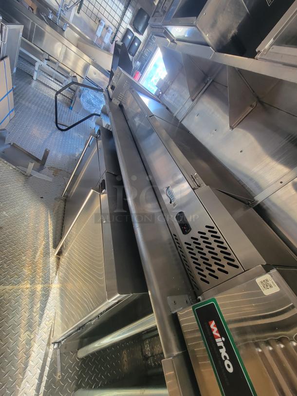 Pristine 2021 Titanium 28' food trailer, unused pro-grade interior, factory protective materials, high-capacity mobile kitchen.