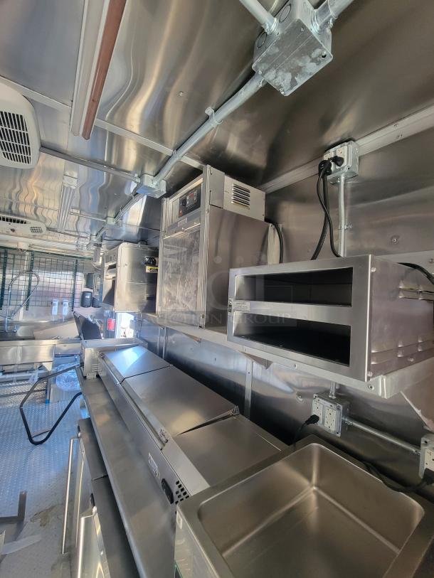 2021 Titanium 28' food trailer interior, pristine condition, unused professional-grade equipment, factory protective material visible.