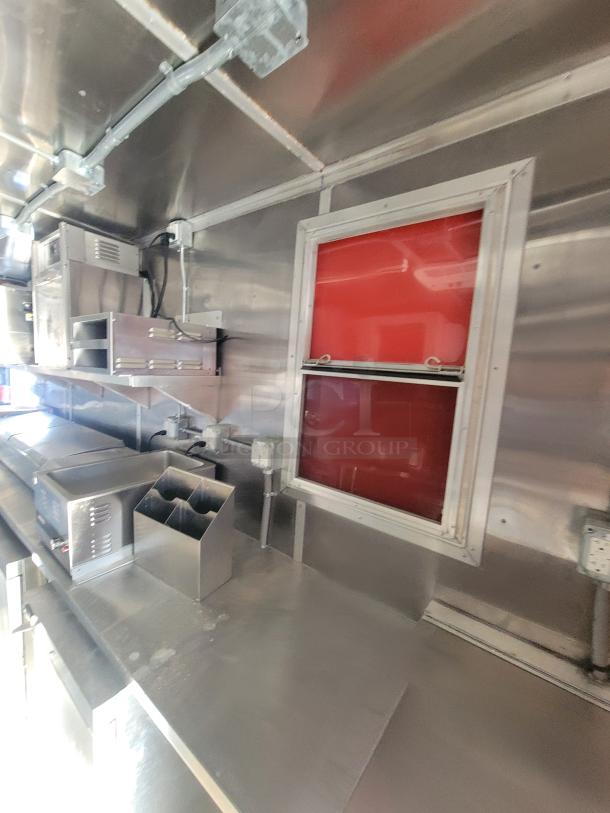 As-new 2021 Titanium 28' food trailer, unused equipment, professional-grade interior, factory protective material visible.