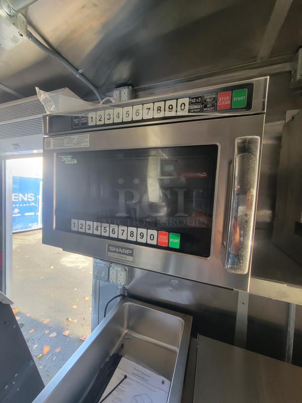 2021 Titanium 28' food trailer interior with unused Sharp commercial microwave, protective material intact. Pristine condition.