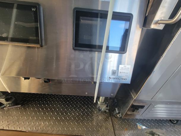 Pristine 2021 Titanium 28' food trailer interior with unused professional-grade equipment, featuring protective factory material. Garland service sticker visible.