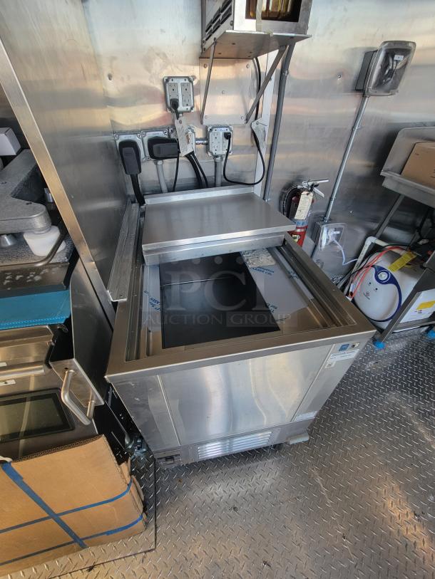 As-new 2021 Titanium 28' food trailer with unused professional-grade equipment, visible factory protective material.