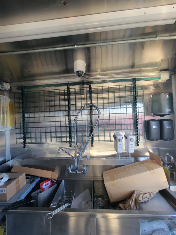 2021 Titanium 28' food trailer interior, pristine condition, unused professional kitchen setup, visible factory protective material.