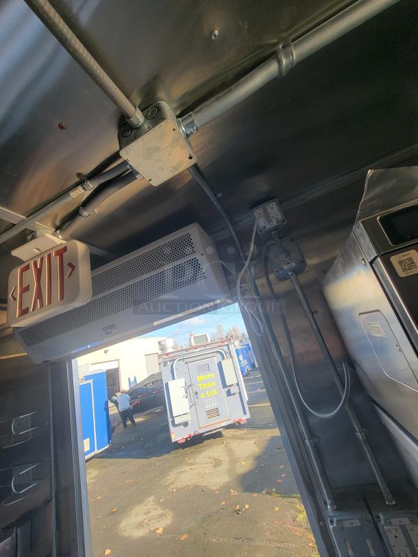 As-new 2021 Titanium 28' food trailer interior, showcasing unused professional-grade equipment with protective material.