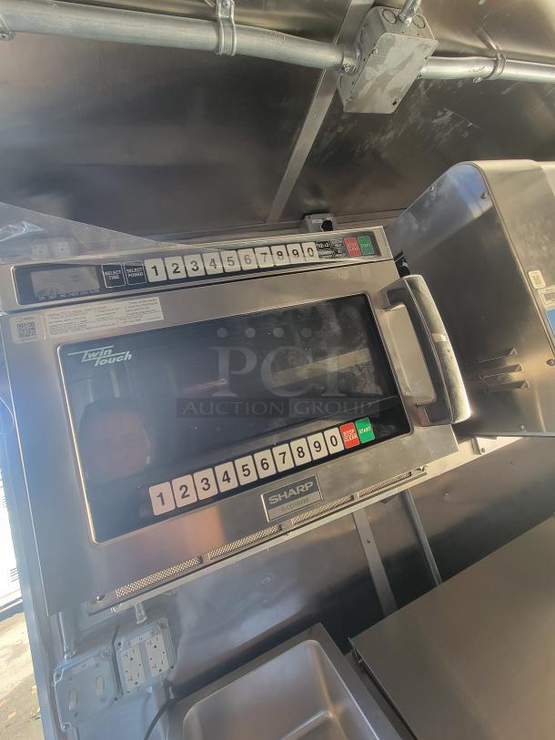 2021 Titanium 28' food trailer interior showing new, unused Sharp microwave with protective material.