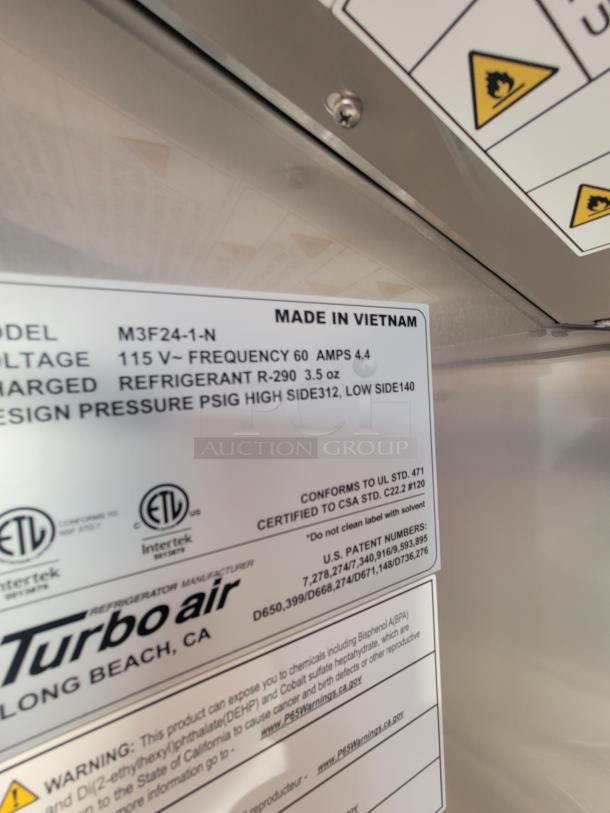 Label inside a Titanium 28' food trailer shows specifications: Model M3F24-1-N, voltage 115V, refrigerant R-290. Made in Vietnam. Turbo Air branding.